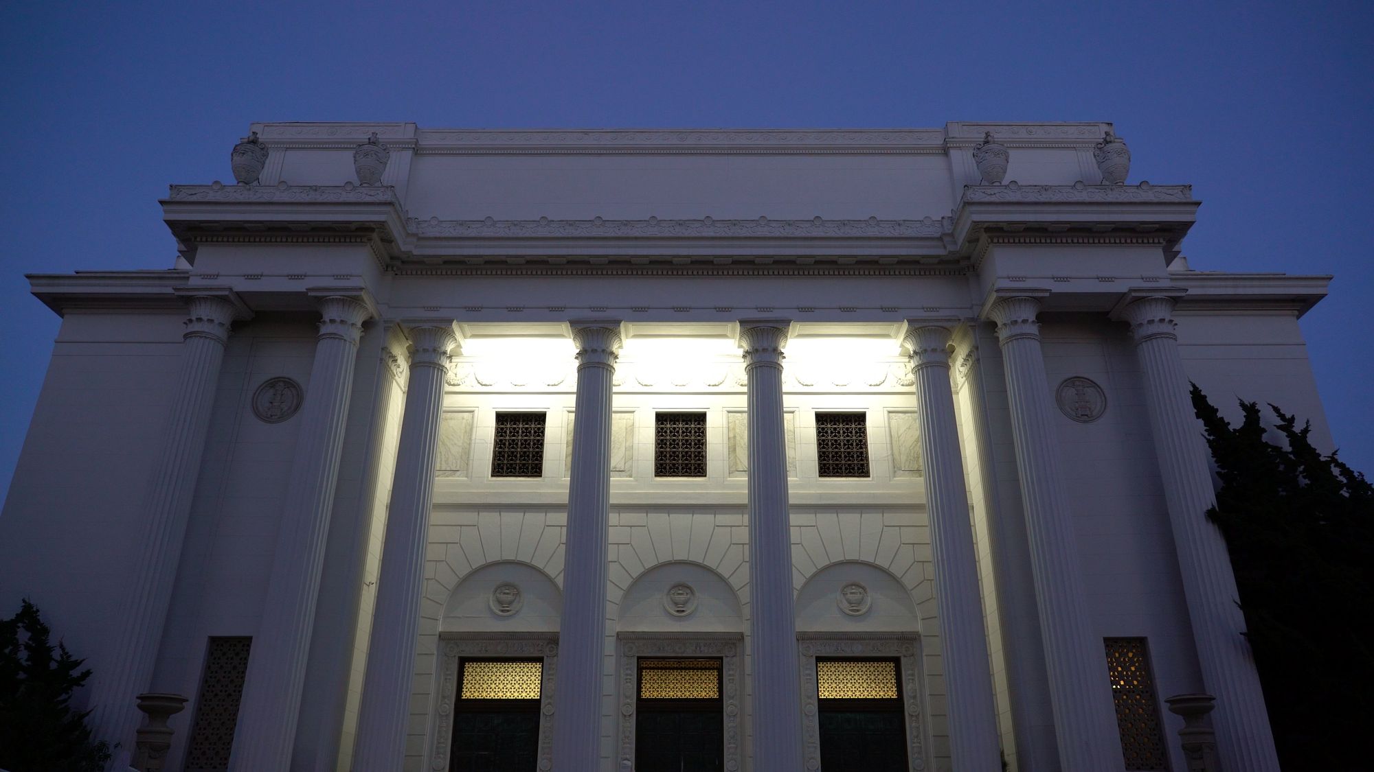 A white neoclassical building at dusk.