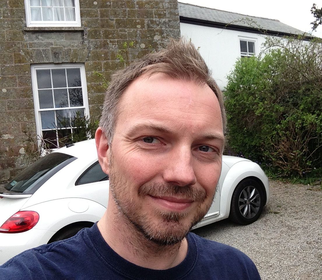 A man standing in front of a white car.